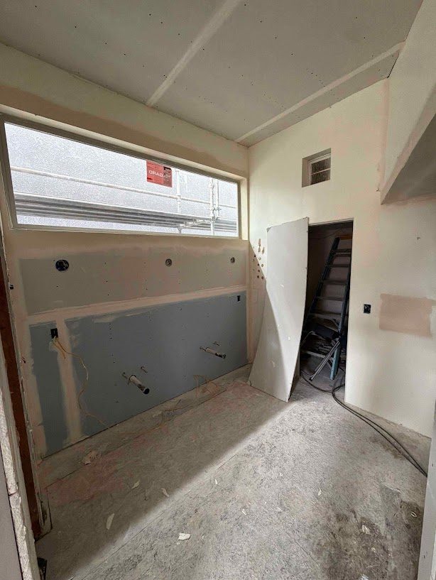 Drywall and moisture-resistant board hung in a bathroom, ready for mud and tape